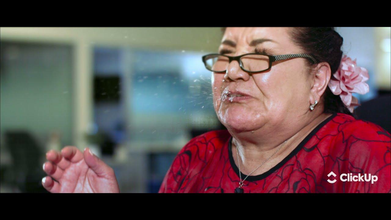 A woman sneezing violently in the office.